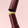 An on-the-go tube of VMAGIC® Lips Stick by Medicine Mama on a pink background.