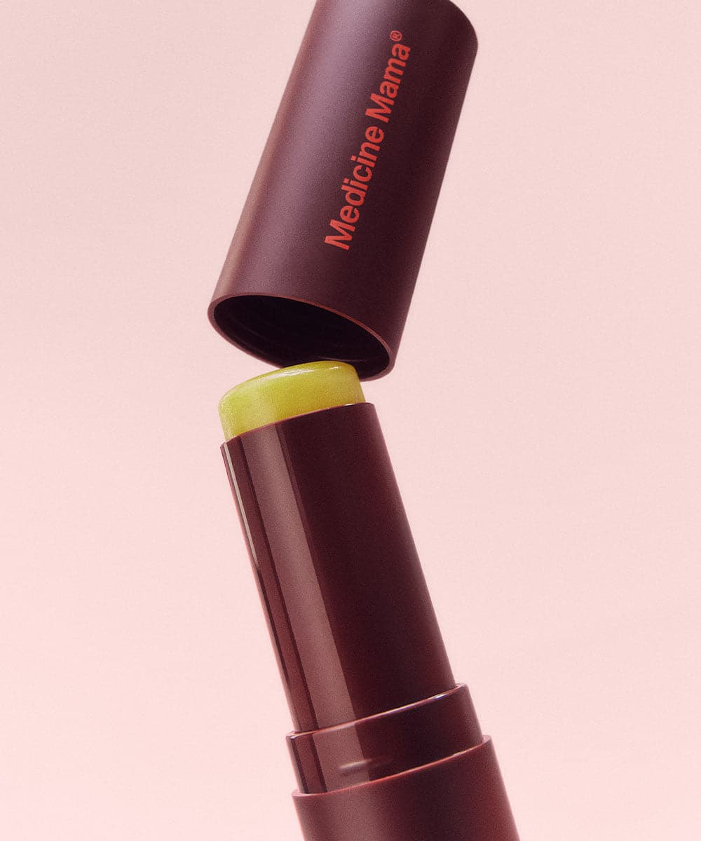 An on-the-go tube of VMAGIC® Lips Stick by Medicine Mama on a pink background.