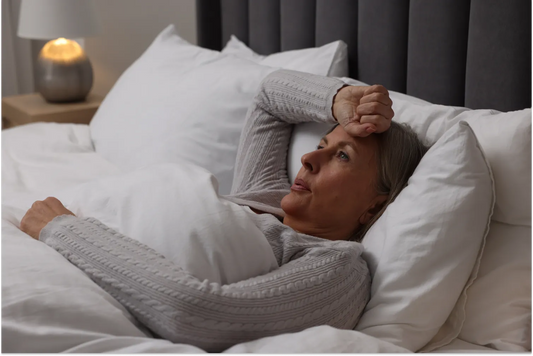 A woman suffering from hot flash in bed; night sweat.