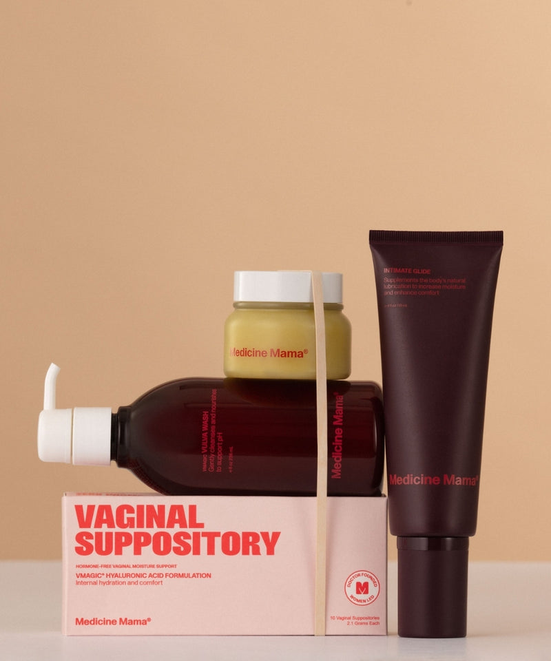 The VMAGIC® Ultimate Intimacy Kit, featuring a gentle wash, suppositories, moisturizer jar, pump bottle, and tube, is displayed on a light beige surface against a tan background.