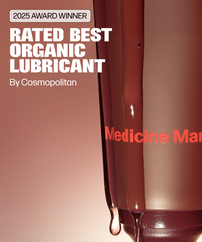 Close-up of a brown bottle labeled “2025 Award Winner Rated Best Organic Personal Lubricant By Cosmopolitan” with partial “Medicine Ma” branding, showcasing Intimate Glide and liquid dripping from the bottle.