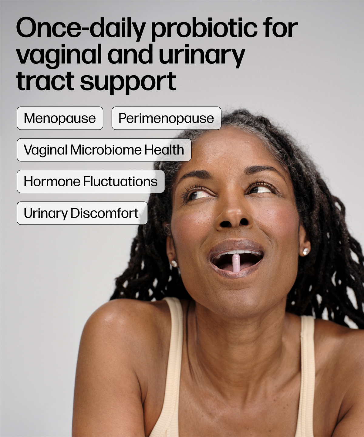 A smiling woman with dark curly hair looks upward against a light gray background, with text reading 'Once-daily probiotic for vaginal and urinary tract support' and labels for Menopause, Perimenopause, Vaginal Microbiome Health, Hormone Fluctuations, and Urinary Discomfort.