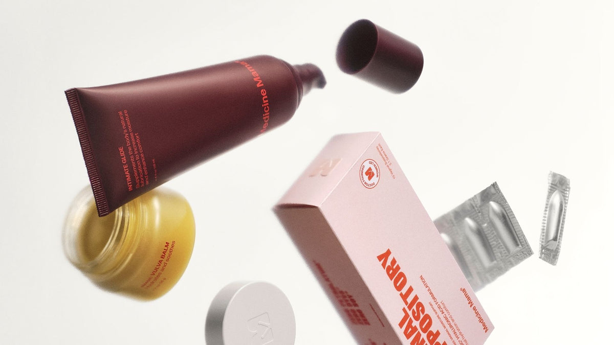 A maroon tube, a yellow jar, an opened box labeled MALEPOSITORY, two pill blister packs, and a round lid float against a white background.