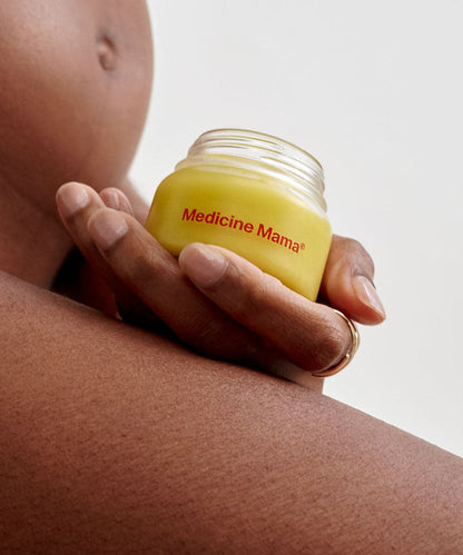 A pregnant woman holding a bundle of Medicine Mama's VMAGIC® Daily Care Duo: Balm & Wash - Preorder ships 1/17/24 for her vulva care routine.