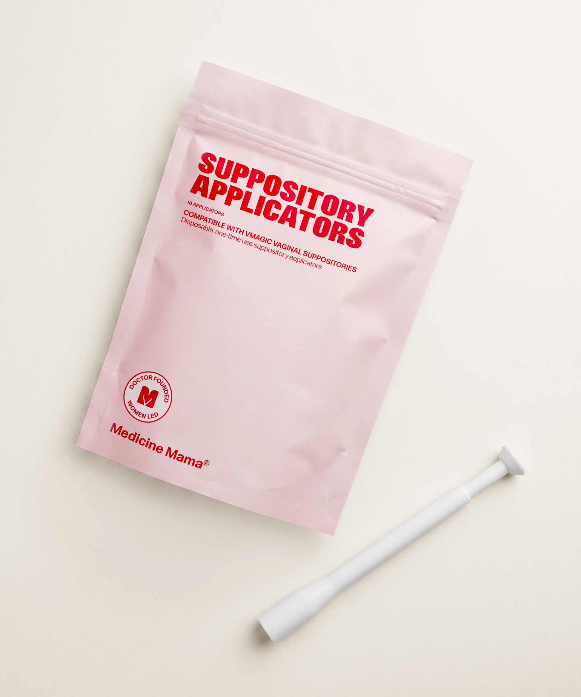 A pink package labeled "Vaginal Suppository Applicators" with the Medicine Mama logo sits beside a white applicator on a beige surface, offering a mess-free way to use vaginal suppositories.